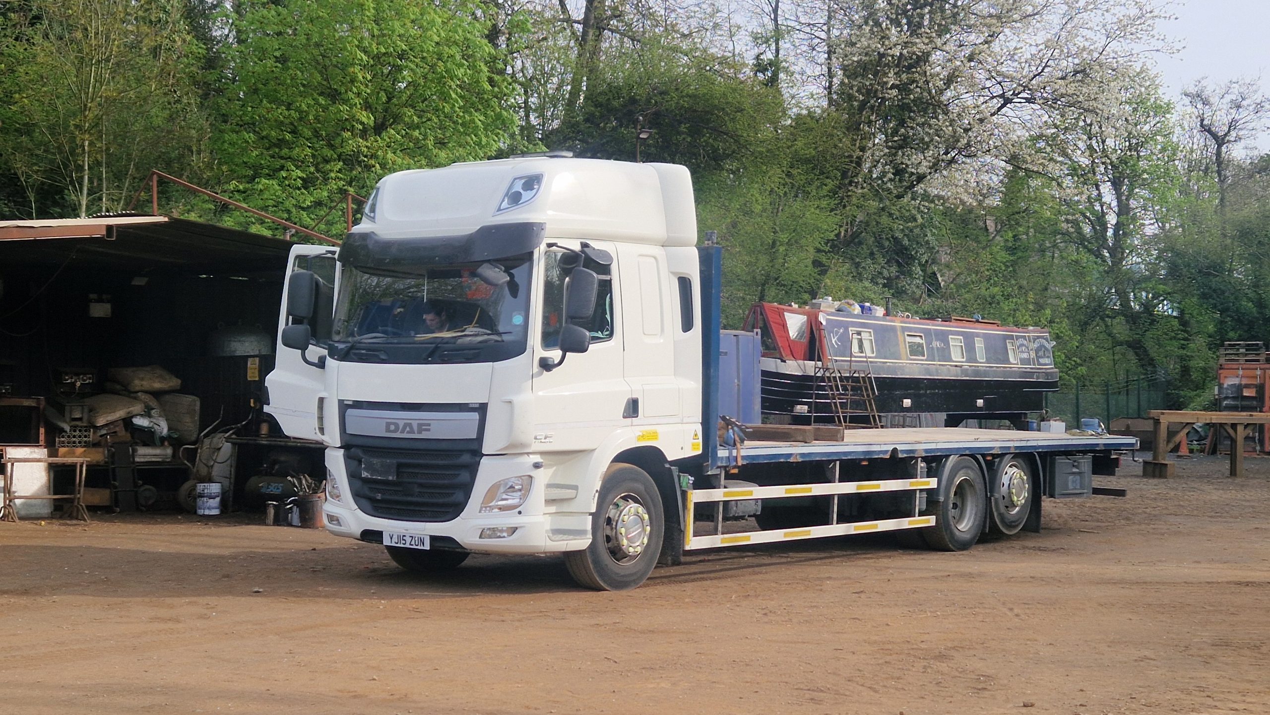 narrowboat being lifted onto lorry for road transport in the UK